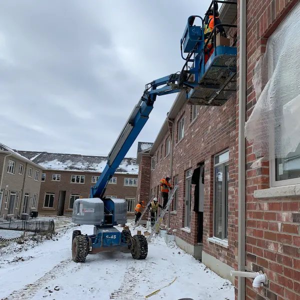 Worker caulking a window