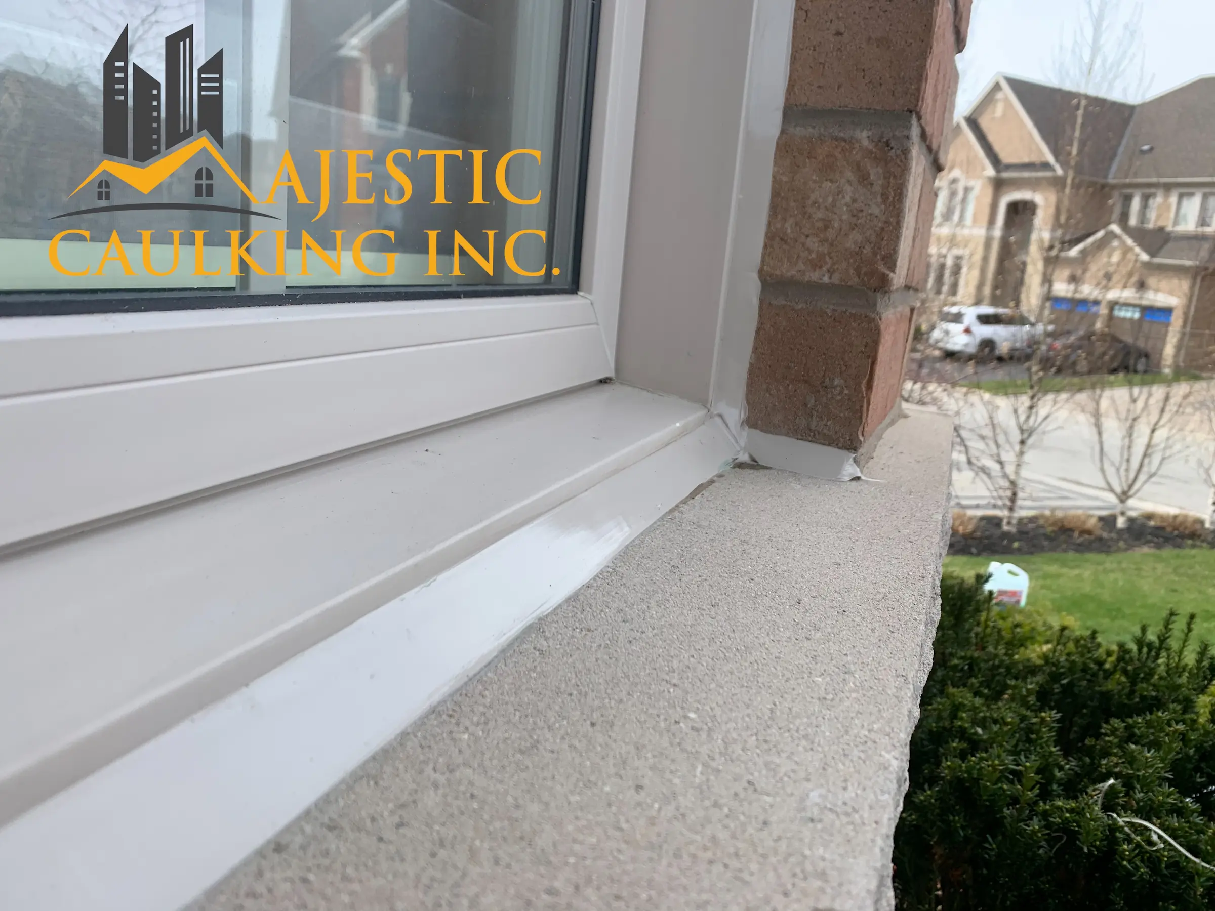 Worker caulking a window